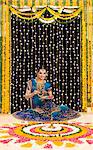 Woman holding a plate of powder paints to make rangoli at Diwali festival