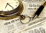 Pocket watch with a pen on Indian five hundred rupee notes