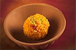 Close-up of a motichoor laddoo (a popular traditional Indian sweet) in a bowl