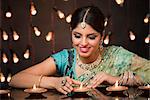 Woman looking at oil lamps on Diwali