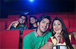 Couple enjoying movie with popcorns in a cinema hall