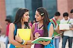 University students discussing on a book in university campus