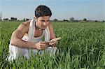 Farmer examining the soil of the field, Sonipat, Haryana, India