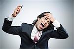 Frustrated businessman holding a mobile phone and shouting