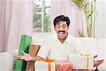 South Indian man smiling near gift boxes