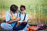 Farmer teaching his daughter in the field, Sohna, Haryana, India