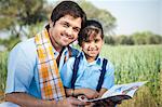 Farmer teaching his daughter and smiling, Sohna, Haryana, India