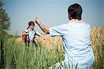 Farmer about to hug his daughter in the field, Sohna, Haryana, India