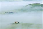 Typical Tuscany landscape with farm in morning with fog near Pienza. Pienza, Siena district, Tuscany, Toscana, Italy.