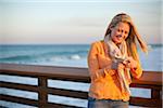 Young Woman Standing on Pier at Beach, Texting on Cell Phone, Jupiter, Palm Beach County, Florida, USA