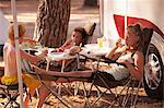 Croatia, Dalmatia, Children Relaxing In Front Of Camp Trailer