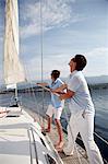 Croatia, Two young men on sailboat setting sail