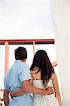 Croatia, Young couple on sailboat arm in arm, rear view