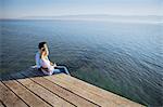 Croatia, Young couple sits on boardwalk, looking at view