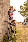 Croatia, Dalmatia, Young woman at the seaside, leaning against wall