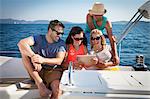 Croatia, Adriatic Sea, Young people on sailboat using Tablet