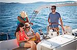 Croatia, Adriatic Sea, Young people on sailboat using Tablet