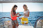 Croatia, Adriatic Sea, Young women on sailboat learn how to tie knots