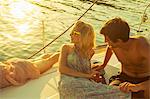 Croatia, Adriatic Sea, Young people on sailboat at sunset