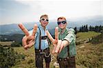 Germany, Bavaria, Two boys with sunglasses making gestures in mountains