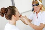 ENT physician Examines the Throat of a Female Patient