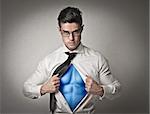 Office worker with glasses opening his shirt like a superhero