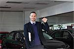 Salesman holding car keys in a dealership