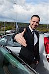 Businessman wanting to shake the hand of someone outdoors