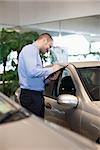 Man holding a folder in a dealership