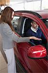 Woman presenting something to a client in a dealership