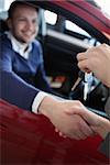Customer receiving car keys while shaking hand in a garage