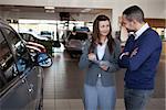 Woman explaining something to a man in a dealership