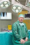 Serious surgeon looking at camera in operating theatre