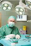 Surgeon sitting in front of surgical tools in a surgical room