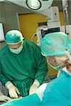 Surgeon holding scissors while operating in am surgical room