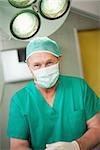 Surgeon smiles as he stands in a surgical room