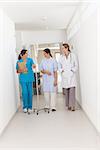 Doctor walking with a patient and a nurse in a hallway