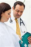 Doctor placing a sphygmomanometer around the arm of his patient in an examination room