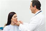 Doctor auscultating the neck of a patient in an examination room