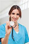 Nurse holding a stethoscope in a hallway