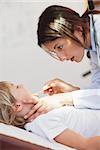 Serious doctor examining a child in examination room