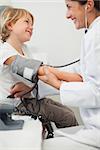 Doctor examining blood pressure of a child in examination room