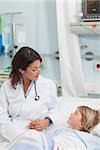 Doctor holding the hand of a child in hospital ward