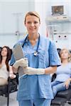 Nurse standing while holding a clipboard in hospital ward