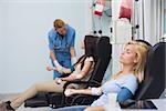 Nurse taking care of a blood donor in hospital ward