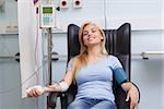 Smiling patient being transfused in hospital ward