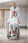 Doctor and patient looking at camera in hospital hallway