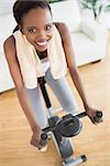 High view of a black woman on an exercise bike in a living room