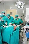 Surgeons and nurses around a patient in an operating theatre