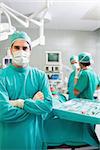 Surgeon looking at camera with arms crossed in an operating theatre